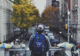 A person with a backpack is standing on the street.